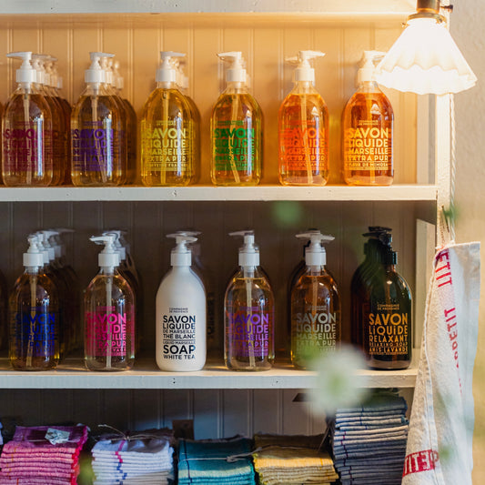 Shelf with various bottles of soap and cleaning products in a store setting.