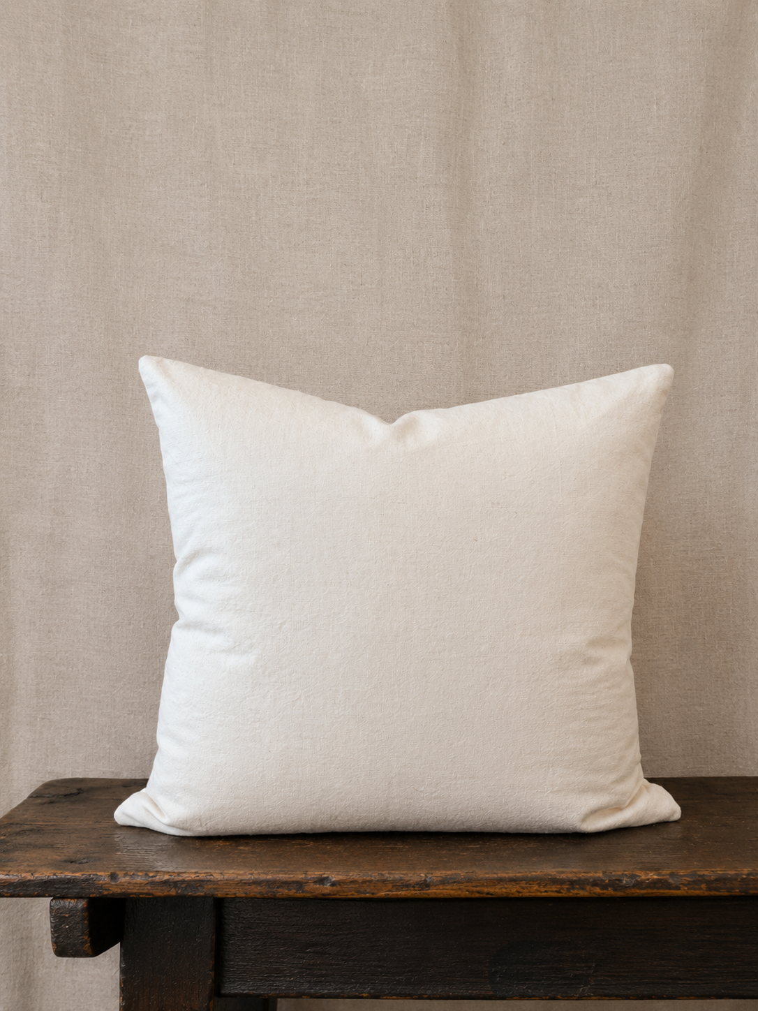 Back of pillow on a wooden surface with a beige background