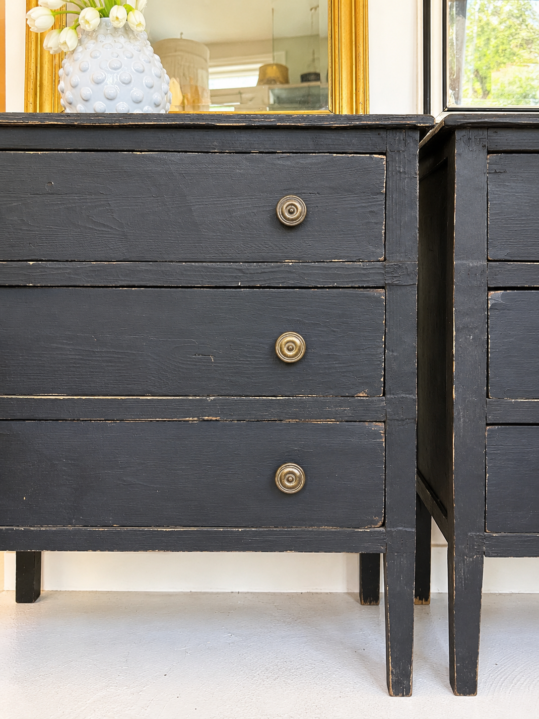 Dark wooden dresser with brass knobs in a room setting