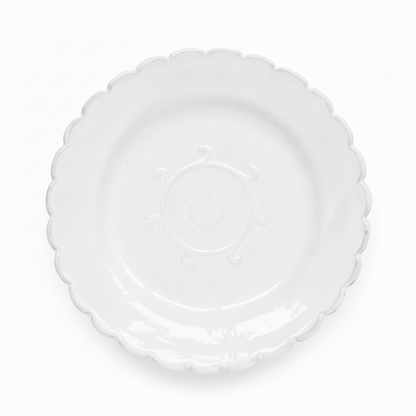 Clear plastic plate with scalloped edge on a white background