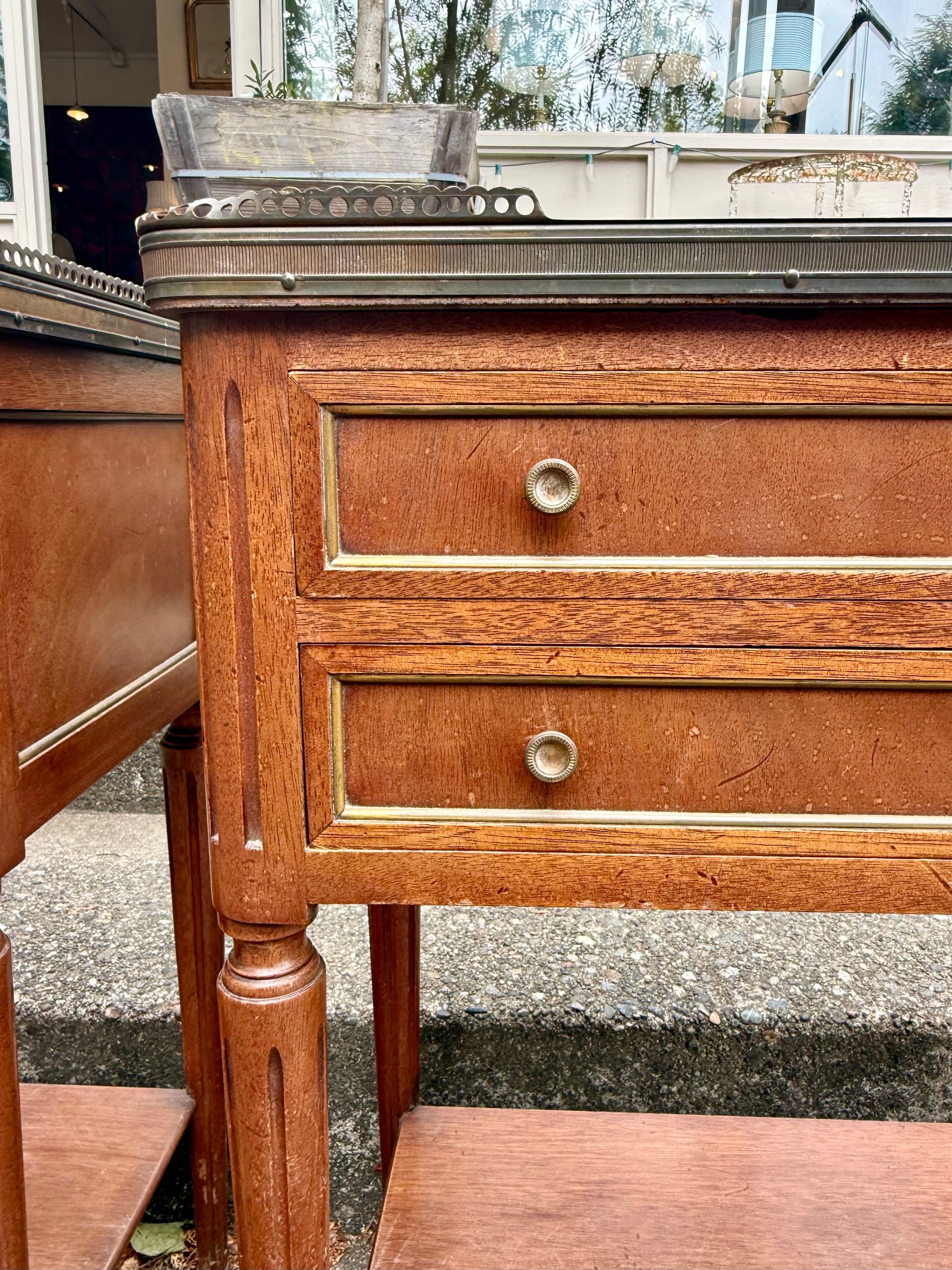Wooden side table with two drawers and a glass top.