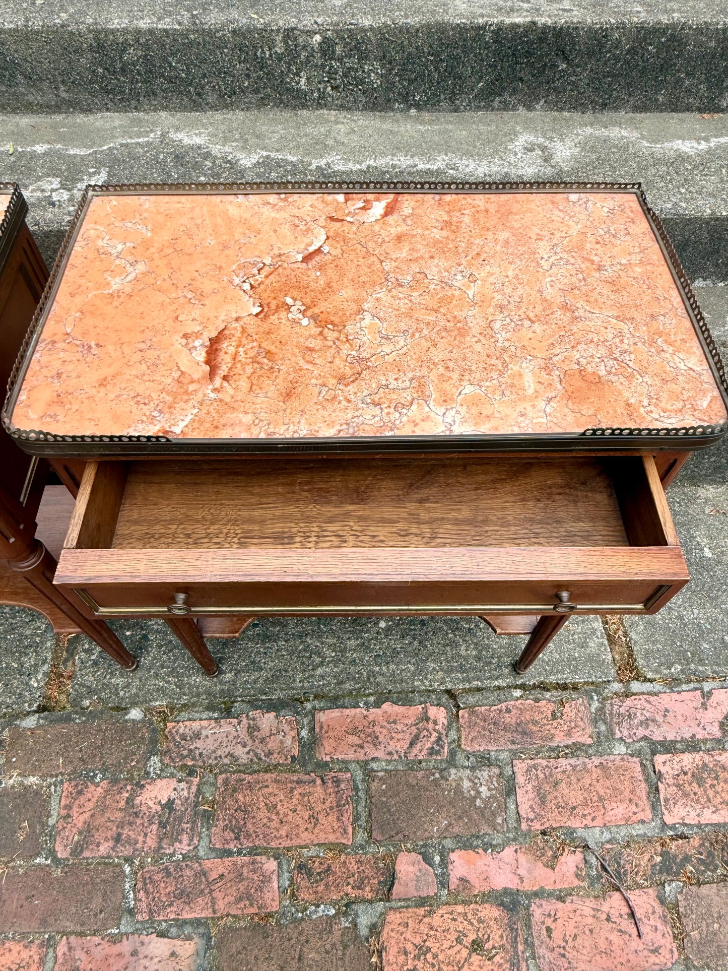 Marble-top table with a drawer on a stone pavement