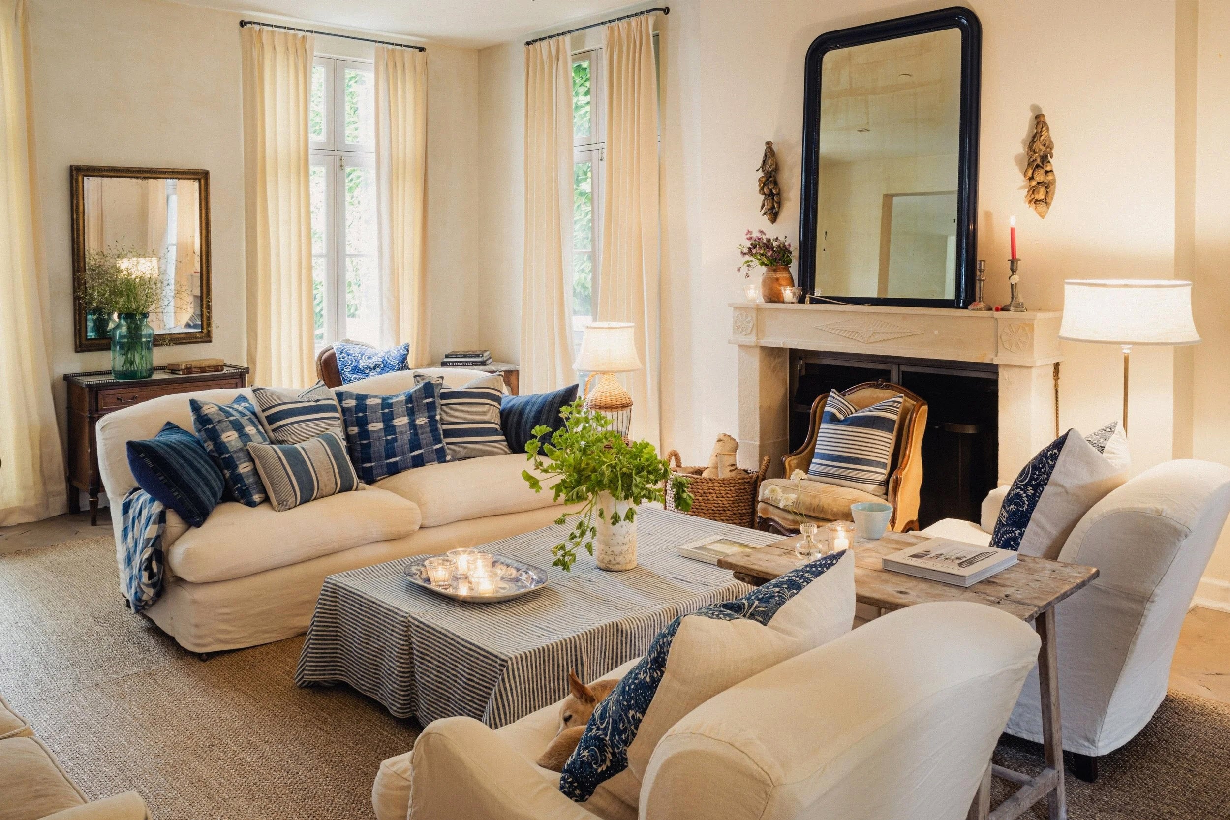 Living room with beige sofa, armchair, and coffee table with decorative items.