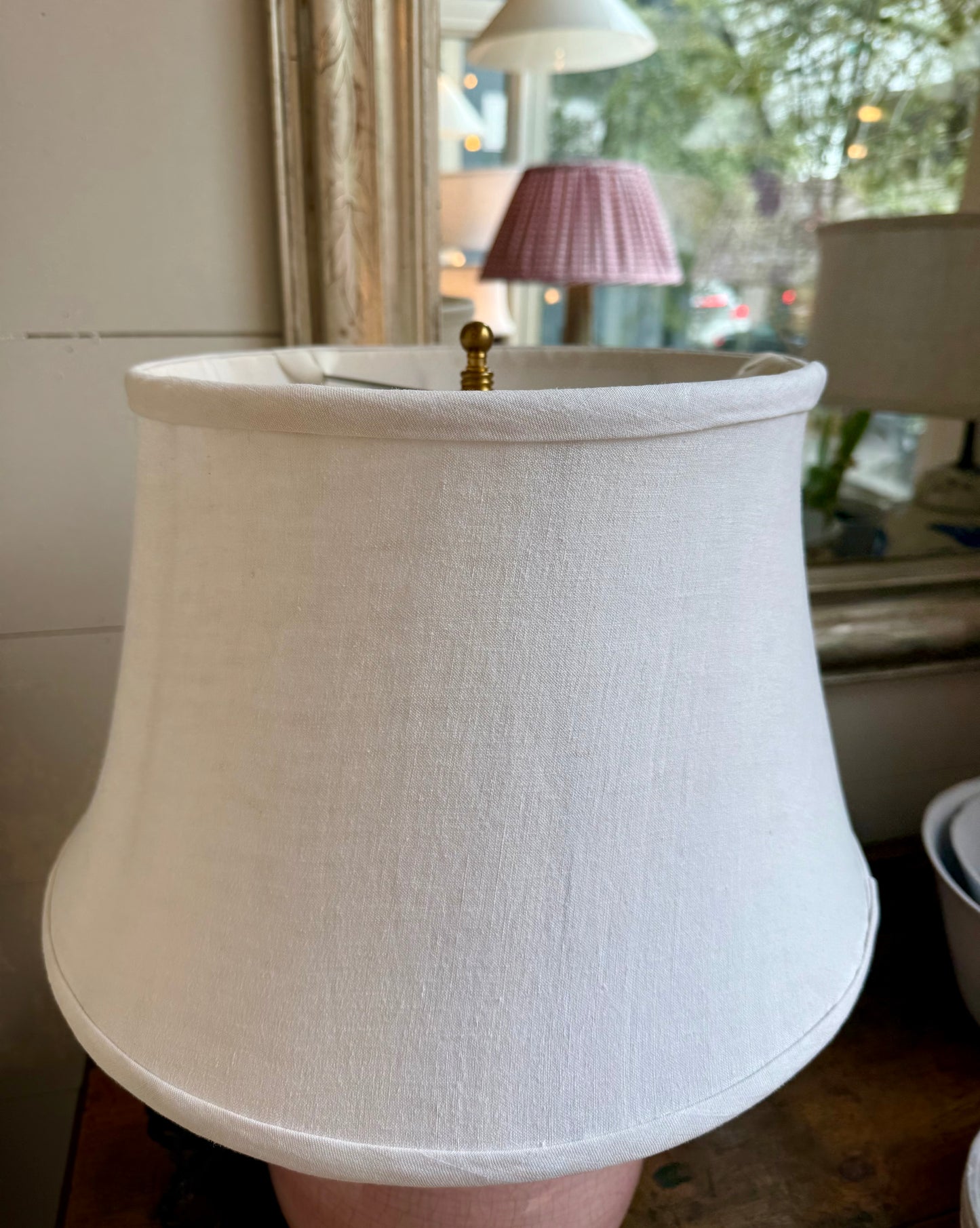 White lampshade with a gold fixture in a room setting