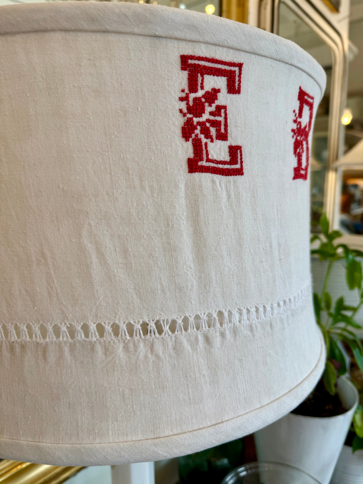 White lampshade with red embroidered design in a home setting