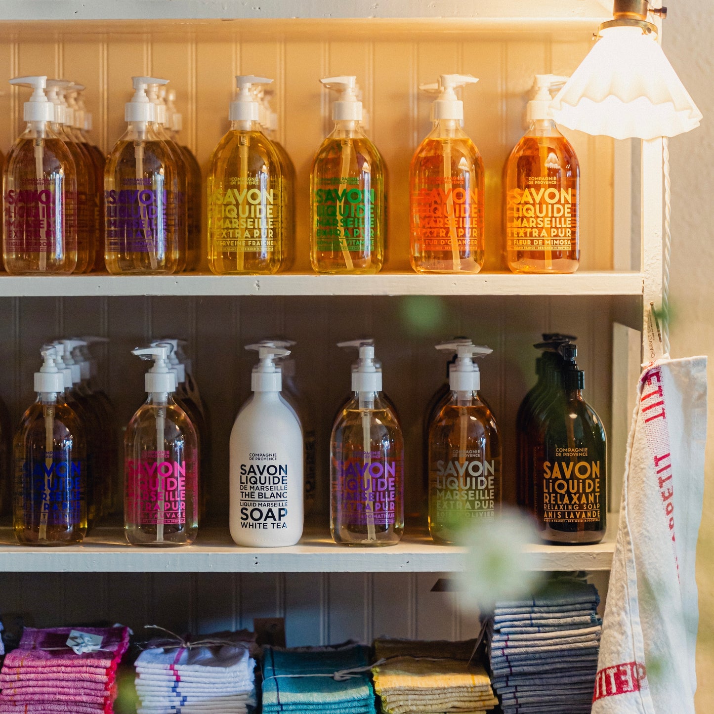 Shelf with various bottles of soap and cleaning products in a store setting.