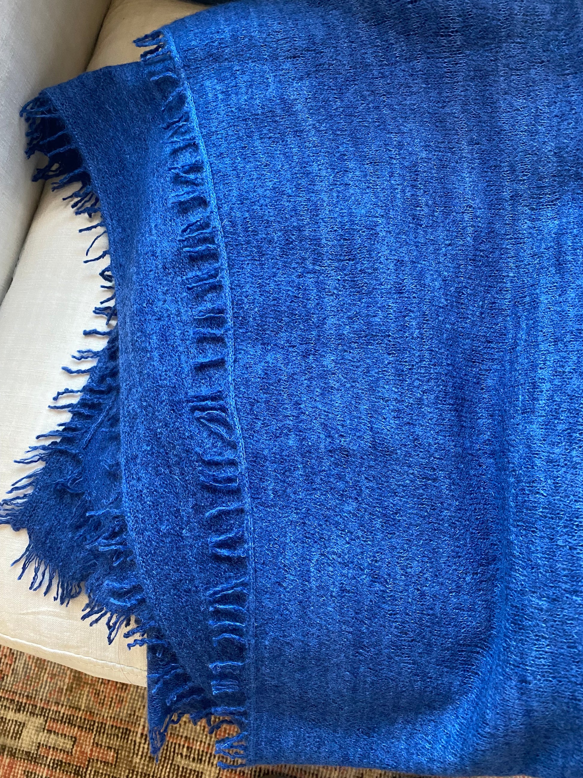 Blue blanket with frayed edges on a surface