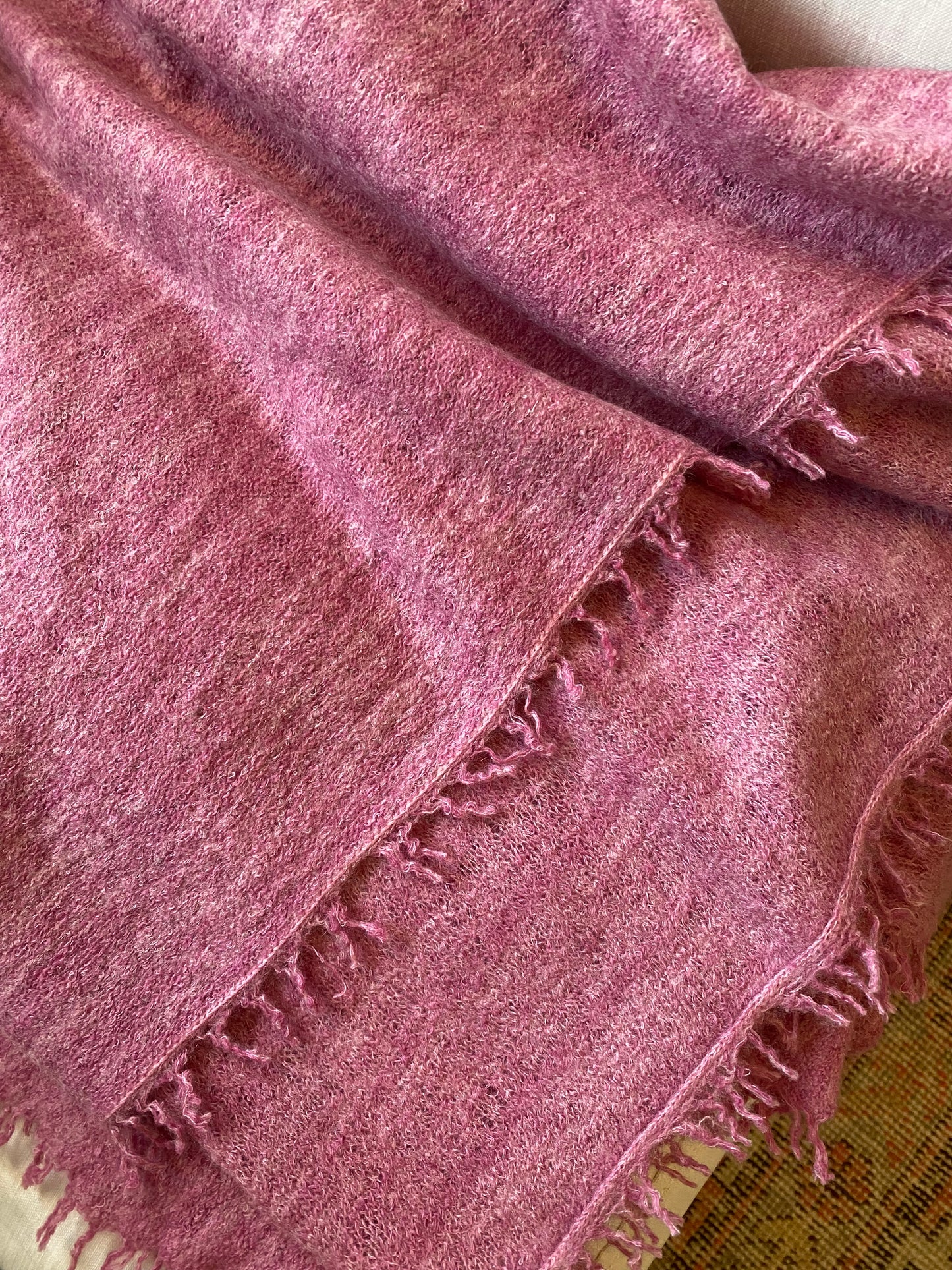 Close-up of a pink textured fabric with frayed edges.
