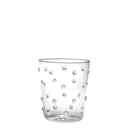 Clear glass tumbler with white polka dot pattern on a white background