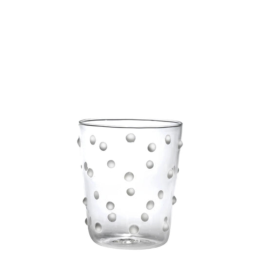 Clear glass tumbler with white polka dot pattern on a white background
