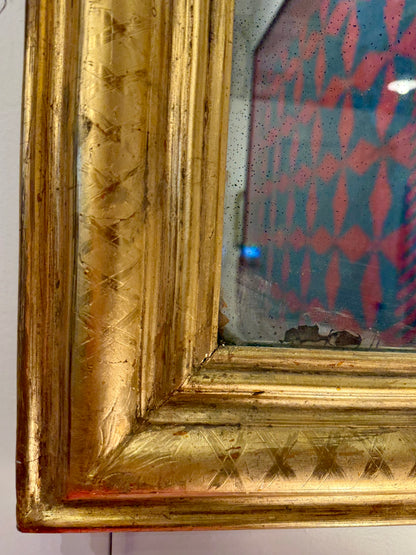 Upclose image of gold ornate frame with reflective surface