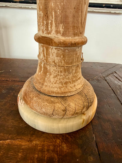Wooden table lamp base on a wooden floor with a white wall background