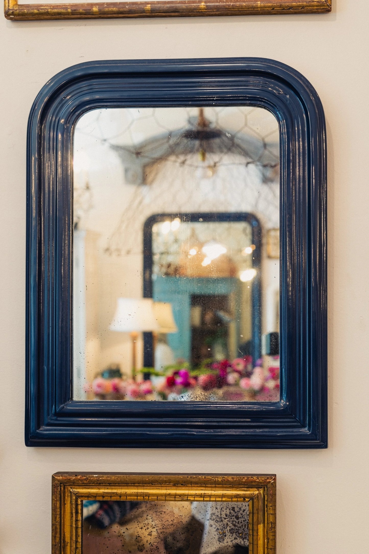 Decorative mirror with a dark blue frame on a wall