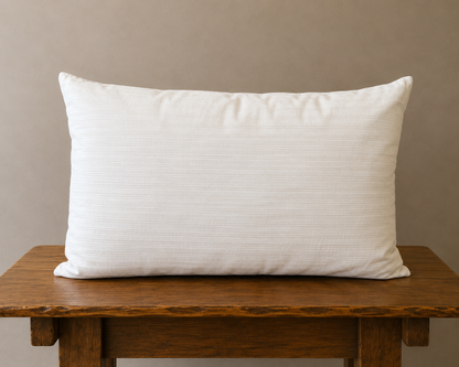 Back of pillow on a wooden table against a beige wall