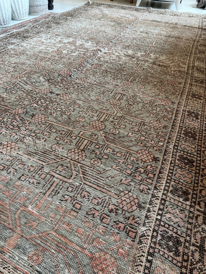 Detailed view of a vintage Khotan rug in wool, showing muted sage and blush tones with patterning.