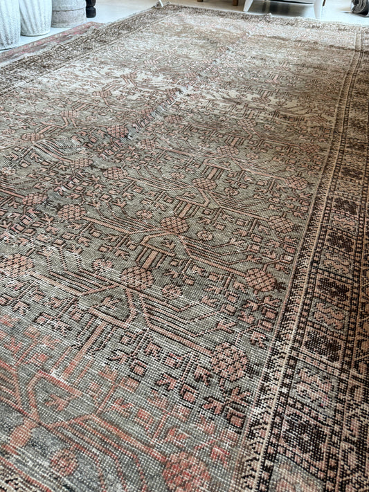Detailed view of a vintage Khotan rug in wool, showing muted sage and blush tones with patterning.