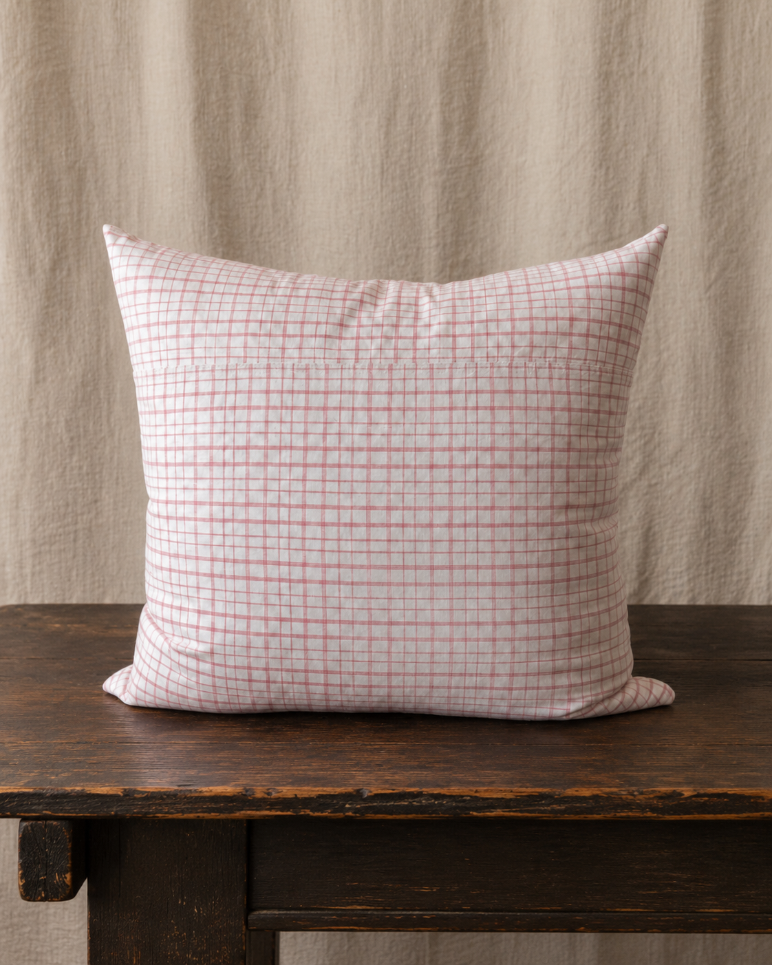 Checkered pillow on a wooden surface with a neutral background