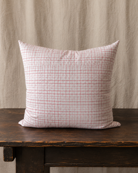 Checkered pillow on a wooden surface with a neutral background