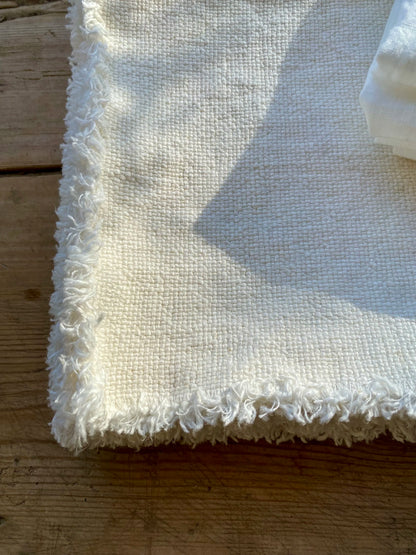 Close-up of edge of Maya linen placemat on a wooden surface