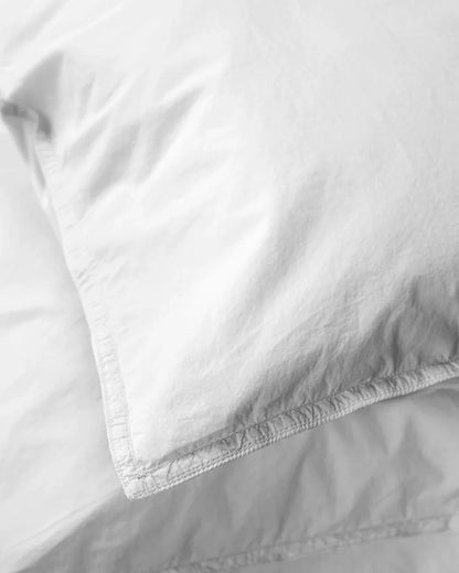 Close-up of white comforter and pillow on a bed