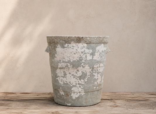 Vintage planter on a wooden surface with a beige background