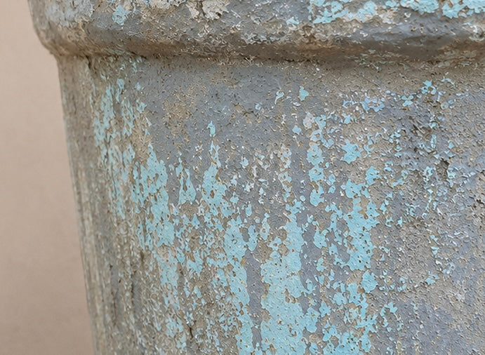 Close-up of a textured stone surface from vintage planter with blue-green discoloration